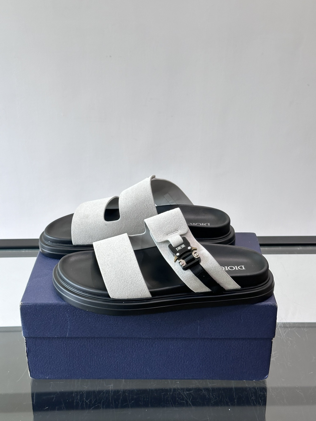 Dior Aqua 男士凉鞋拖鞋。展现 Dior 高订风格设计。迪奥灰绒面革饰带点缀以铝质 Dior 搭扣提升格调。搭配