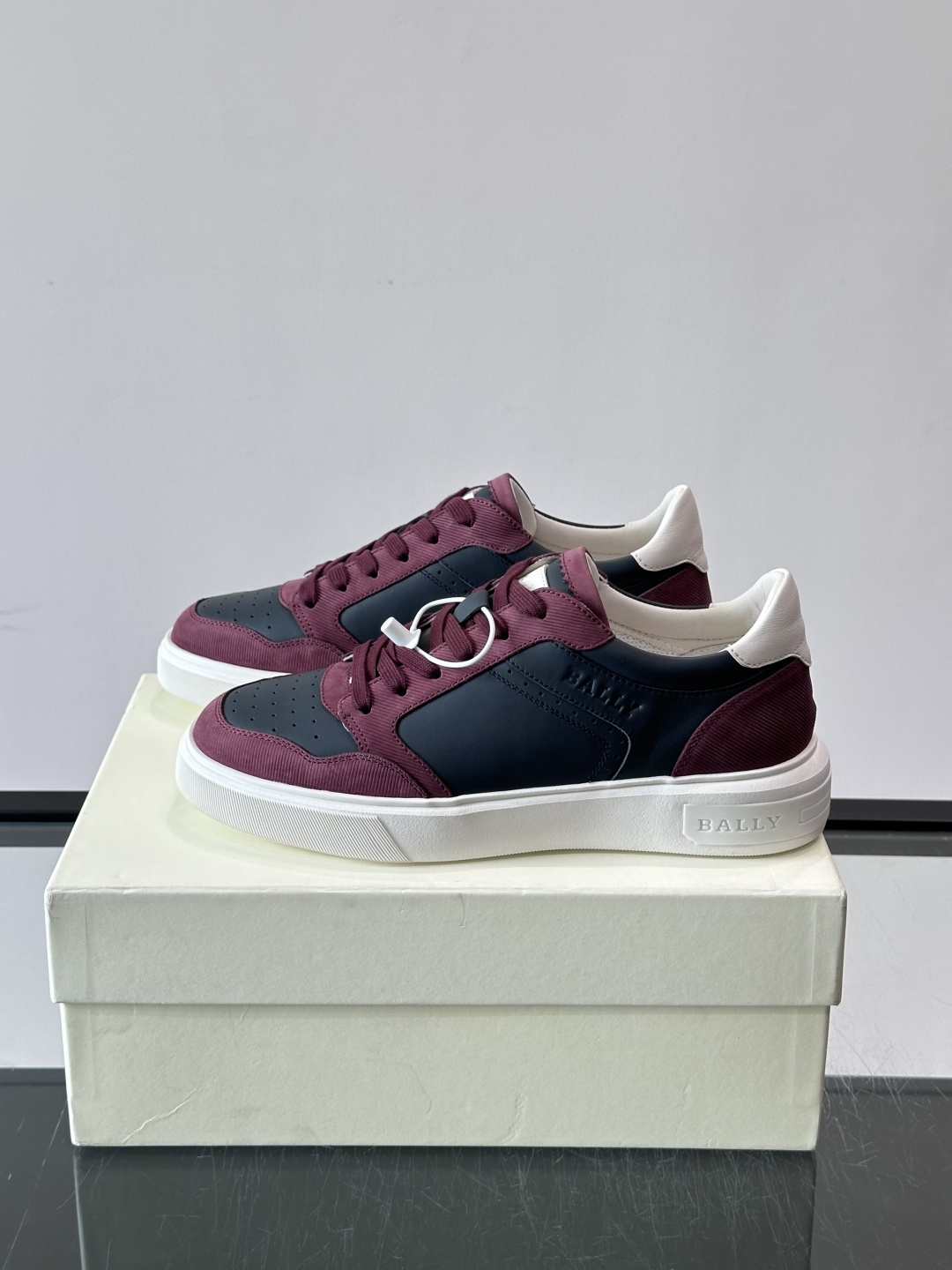 Bally B-Stroke 板鞋,皮革搭配麂皮拼接,酒红色鞋舌点缀,橡胶厚底,鞋侧有"BALLY"压印。 这款 Bally B-Stroke 板鞋,皮革搭配麂皮拼接,酒红色鞋舌点缀,橡胶厚底,鞋侧有"BALLY"压印。 这款