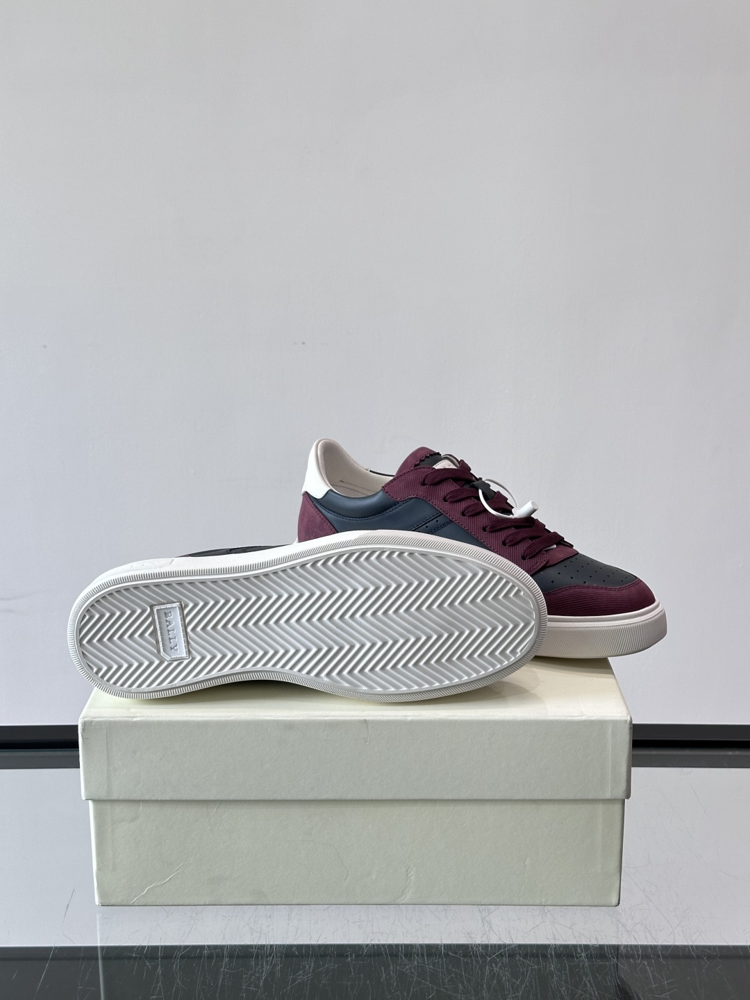 Bally B-Stroke 板鞋,皮革搭配麂皮拼接,酒红色鞋舌点缀,橡胶厚底,鞋侧有"BALLY"压印。 这款 Bally B-Stroke 板鞋,皮革搭配麂皮拼接,酒红色鞋舌点缀,橡胶厚底,鞋侧有"BALLY"压印。 这款