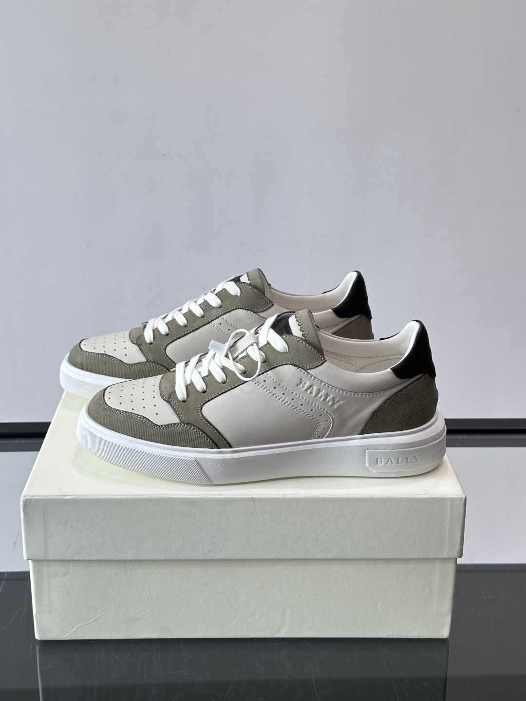 ​​Bally B-Stroke 板鞋​​，皮革搭配麂皮拼接，酒红色鞋舌点缀，橡胶厚底，鞋侧有"BALLY"压印。 这款