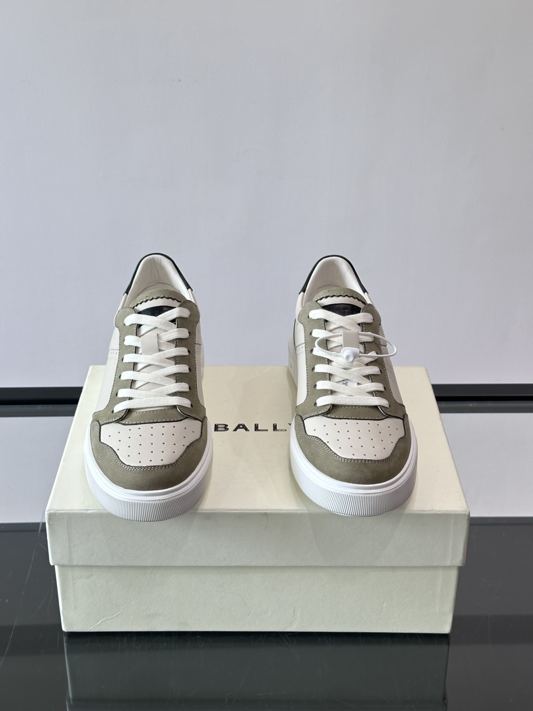 ​​Bally B-Stroke 板鞋​​，皮革搭配麂皮拼接，酒红色鞋舌点缀，橡胶厚底，鞋侧有"BALLY"压印。 这款