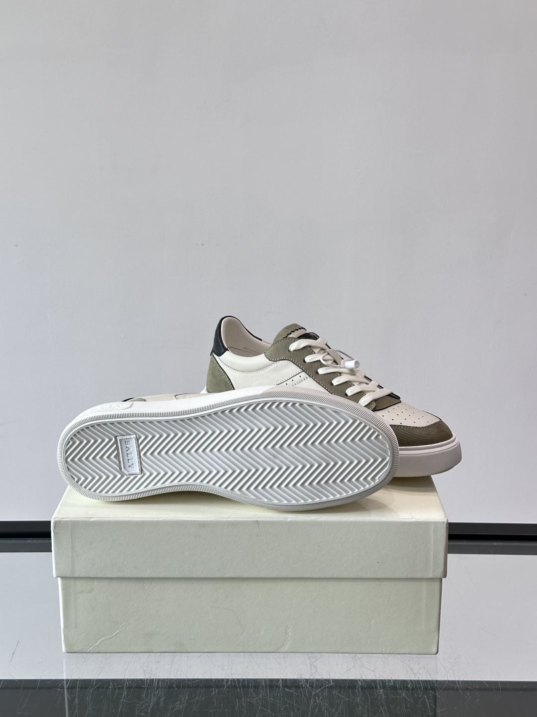 ​​Bally B-Stroke 板鞋​​，皮革搭配麂皮拼接，酒红色鞋舌点缀，橡胶厚底，鞋侧有"BALLY"压印。 这款