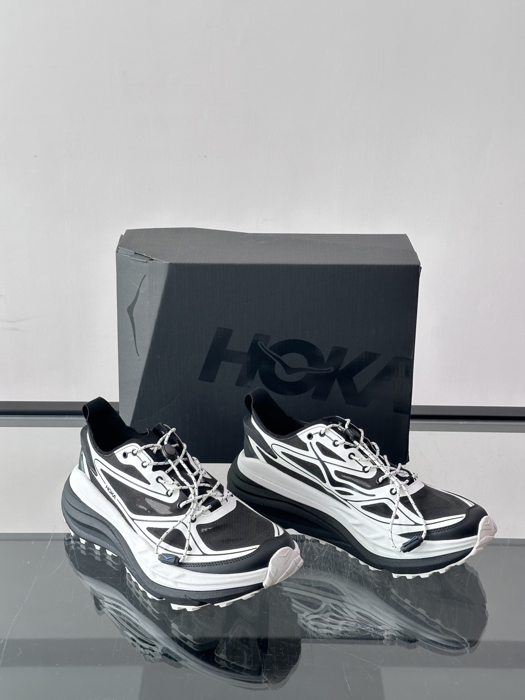 Hoka情侣款👫 越野跑鞋,黑白配色,工程网面鞋身搭配白色波浪形支撑结构,鞋侧有"HOKA"字样,Vibram Hoka情侣款👫 越野跑鞋,黑白配色,工程网面鞋身搭配白色波浪形支撑结构,鞋侧有"HOKA"字样,Vibram