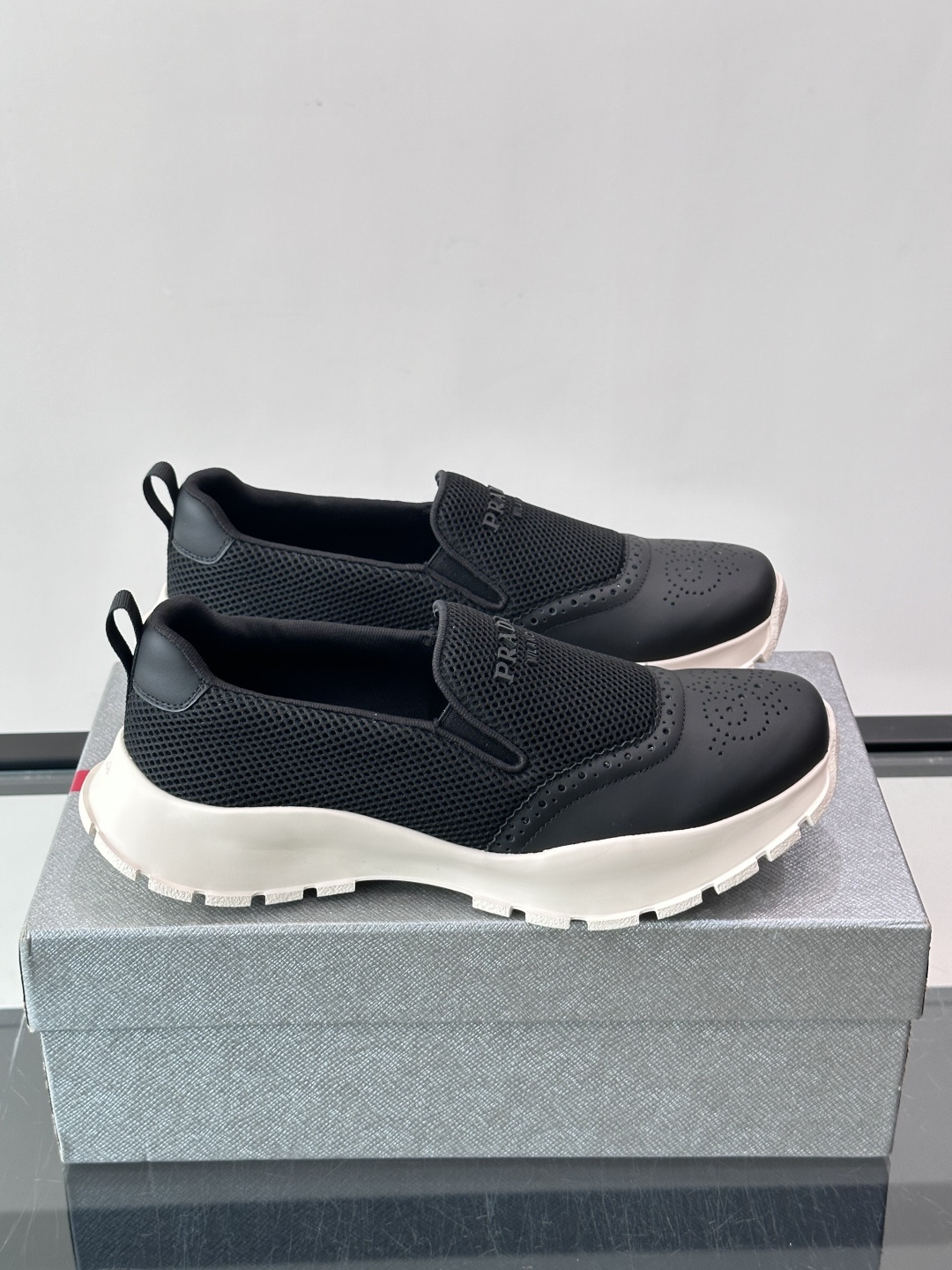 Prada/普拉达 男士新款一脚蹬懒人休闲鞋👟这款运动鞋采用光滑小牛皮革➕透气网面，一脚蹬乐福鞋鞋面，现代简约风格，舒适