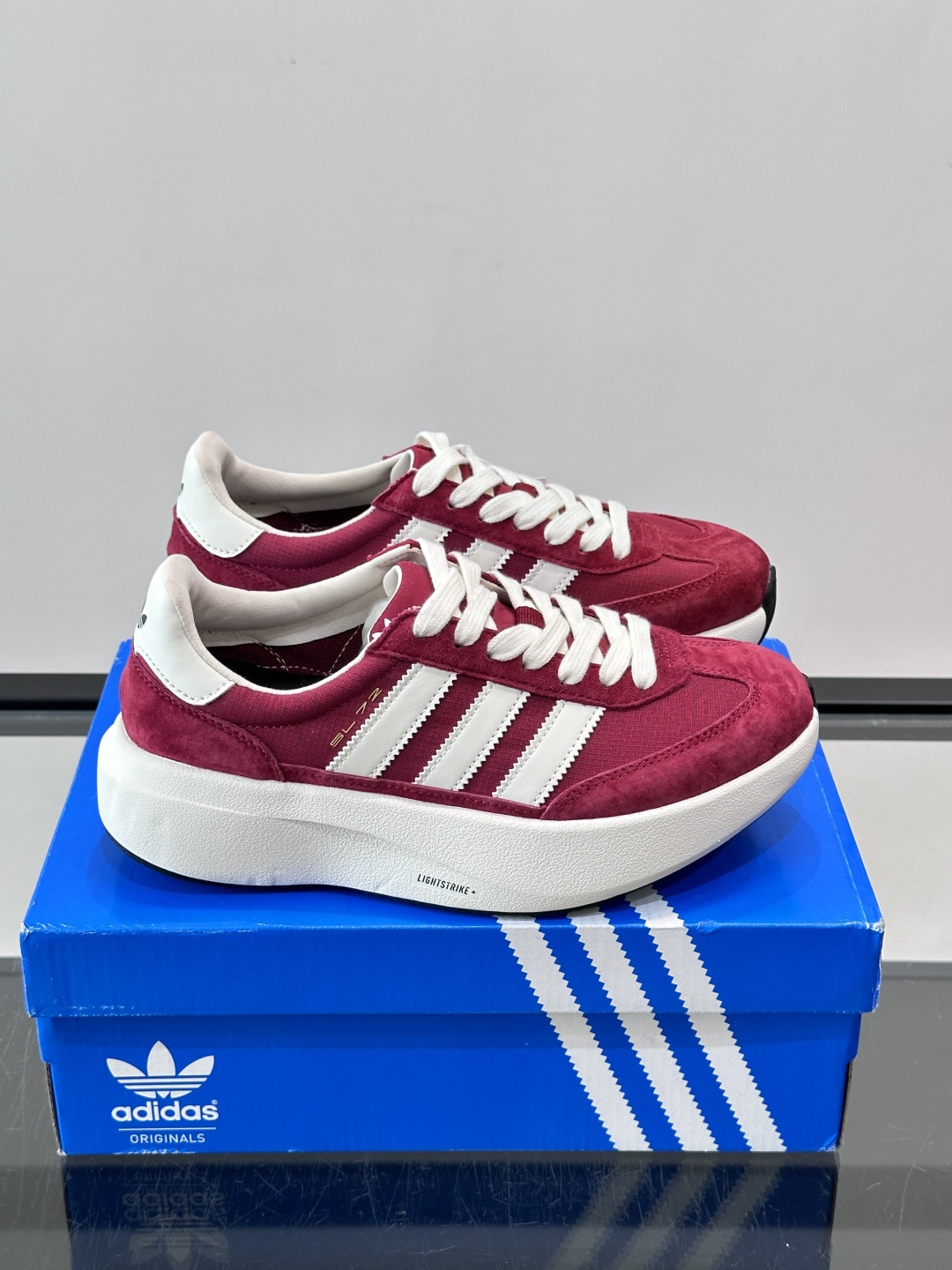 ​​Adidas SL72 运动鞋​​，麂皮+尼龙鞋面，白色三条纹，，厚底侧面有"LIGHTSTRIKE+"字样。这款走