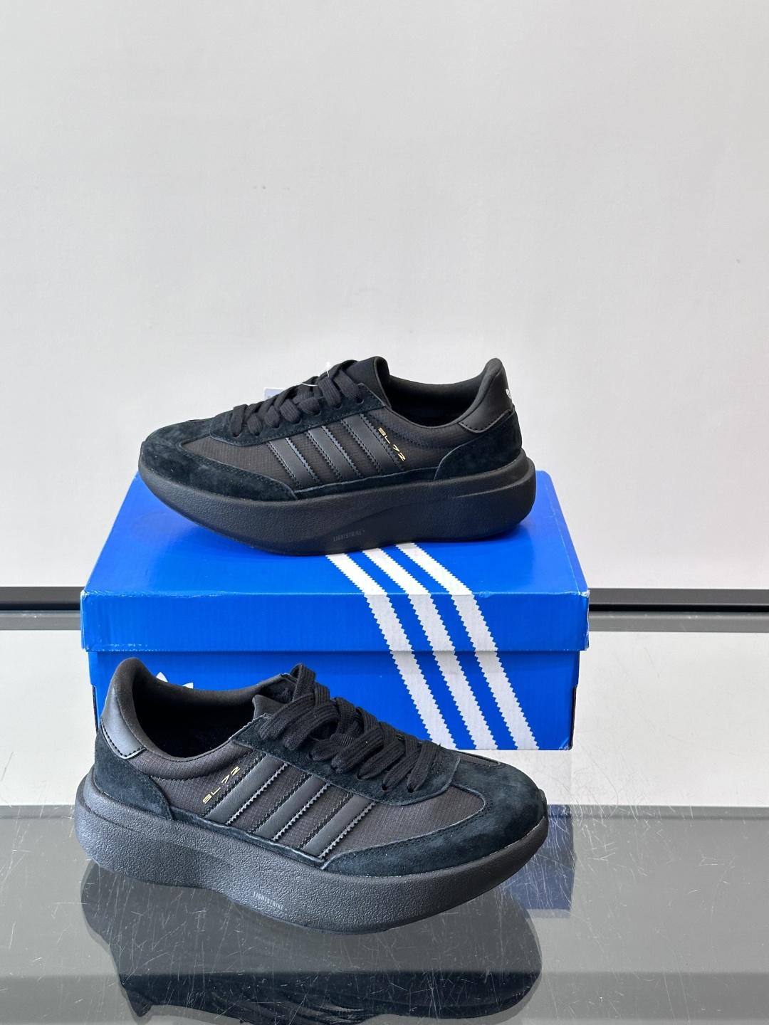 Adidas SL72 运动鞋,麂皮+尼龙鞋面,白色三条纹,,厚底侧面有"LIGHTSTRIKE+"字样。这款走 Adidas SL72 运动鞋,麂皮+尼龙鞋面,白色三条纹,,厚底侧面有"LIGHTSTRIKE+"字样。这款走