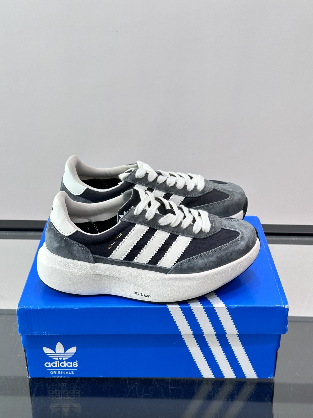 ​​Adidas SL72 运动鞋​​，麂皮+尼龙鞋面，白色三条纹，，厚底侧面有"LIGHTSTRIKE+"字样。这款走