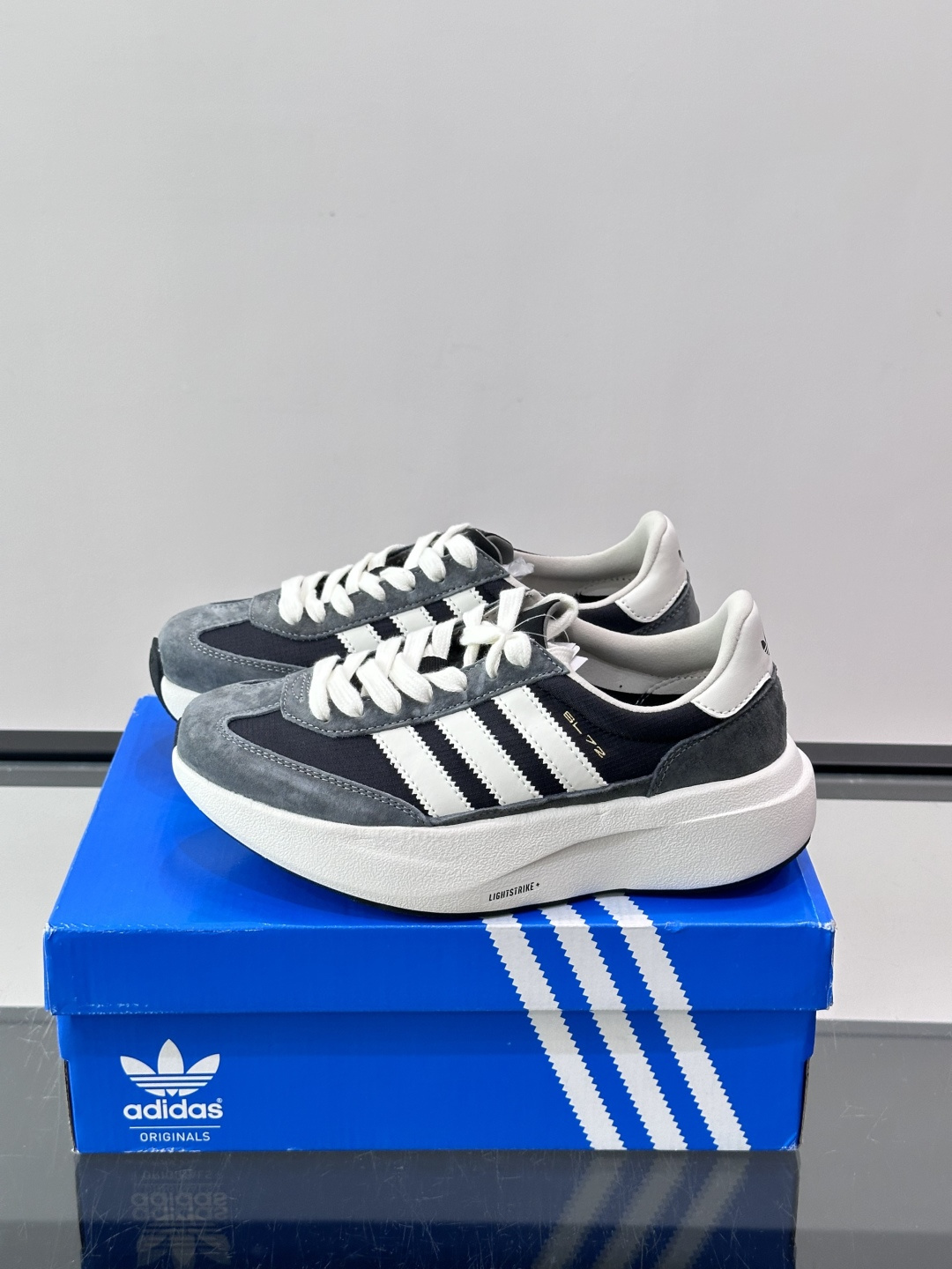 Adidas SL72 运动鞋,麂皮+尼龙鞋面,白色三条纹,,厚底侧面有"LIGHTSTRIKE+"字样。这款走 Adidas SL72 运动鞋,麂皮+尼龙鞋面,白色三条纹,,厚底侧面有"LIGHTSTRIKE+"字样。这款走