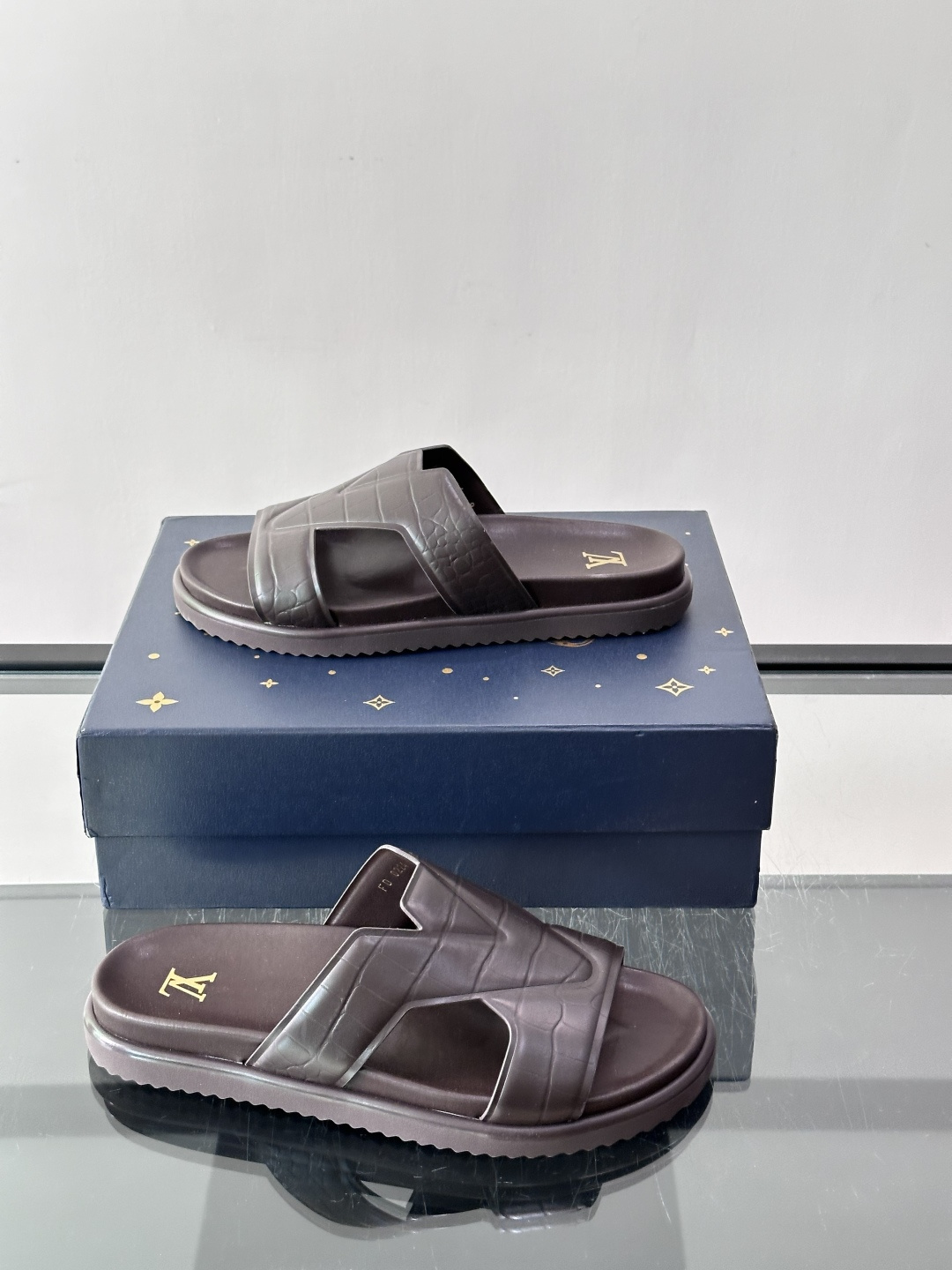 Louis Vuitton 男士皮革拖鞋​​，牛皮交叉带搭配防滑橡胶厚底，鞋垫上有 LV 暗纹 logo。 这款走的是"