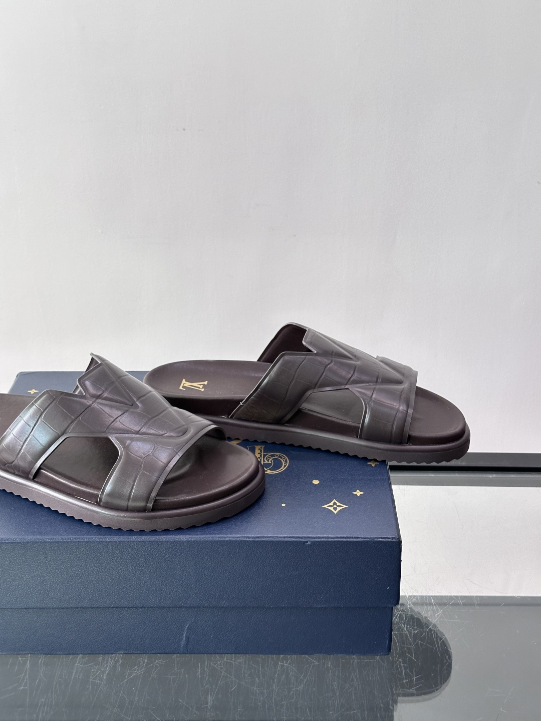 Louis Vuitton 男士皮革拖鞋​​，牛皮交叉带搭配防滑橡胶厚底，鞋垫上有 LV 暗纹 logo。 这款走的是"