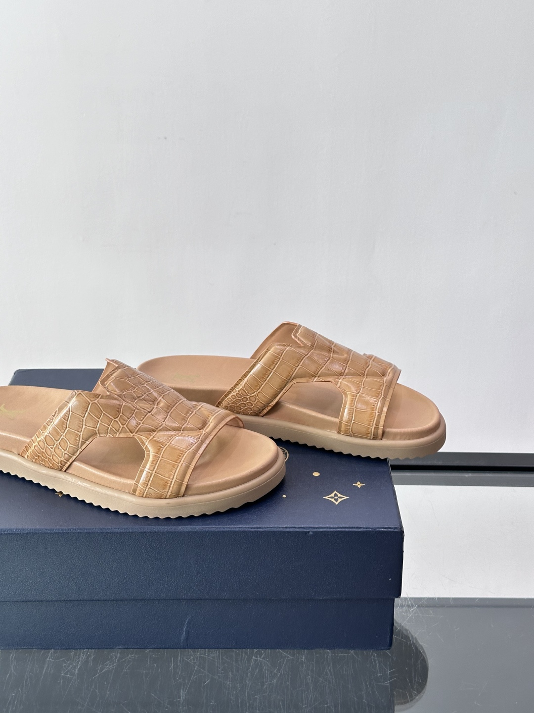 Louis Vuitton 男士皮革拖鞋​​，牛皮交叉带搭配防滑橡胶厚底，鞋垫上有 LV 暗纹 logo。 这款走的是"