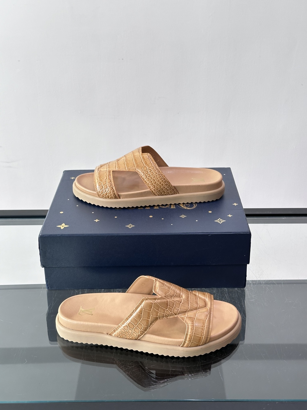 Louis Vuitton 男士皮革拖鞋​​，牛皮交叉带搭配防滑橡胶厚底，鞋垫上有 LV 暗纹 logo。 这款走的是"