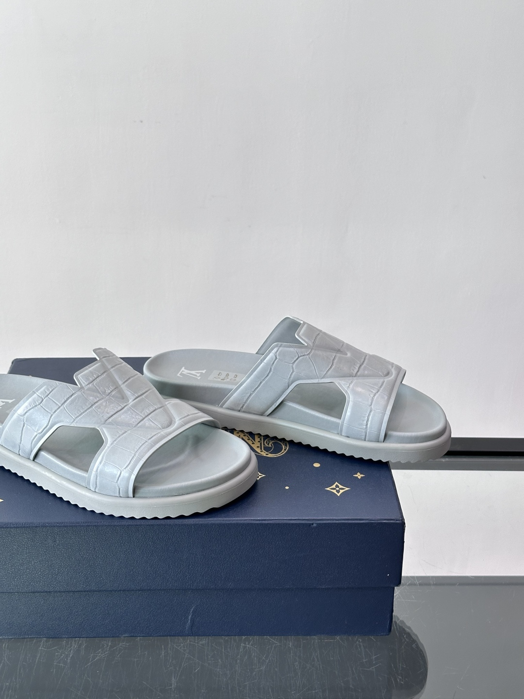 Louis Vuitton 男士皮革拖鞋​​，牛皮交叉带搭配防滑橡胶厚底，鞋垫上有 LV 暗纹 logo。 这款走的是"