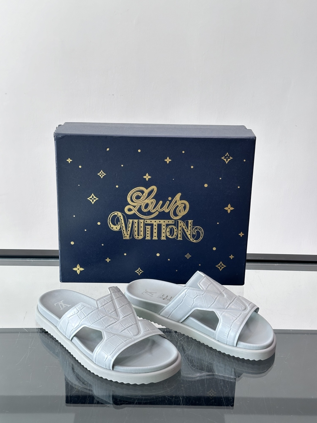 Louis Vuitton 男士皮革拖鞋​​，牛皮交叉带搭配防滑橡胶厚底，鞋垫上有 LV 暗纹 logo。 这款走的是"