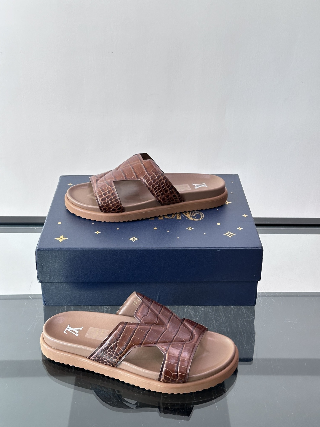 Louis Vuitton 男士皮革拖鞋​​，牛皮交叉带搭配防滑橡胶厚底，鞋垫上有 LV 暗纹 logo。 这款走的是"