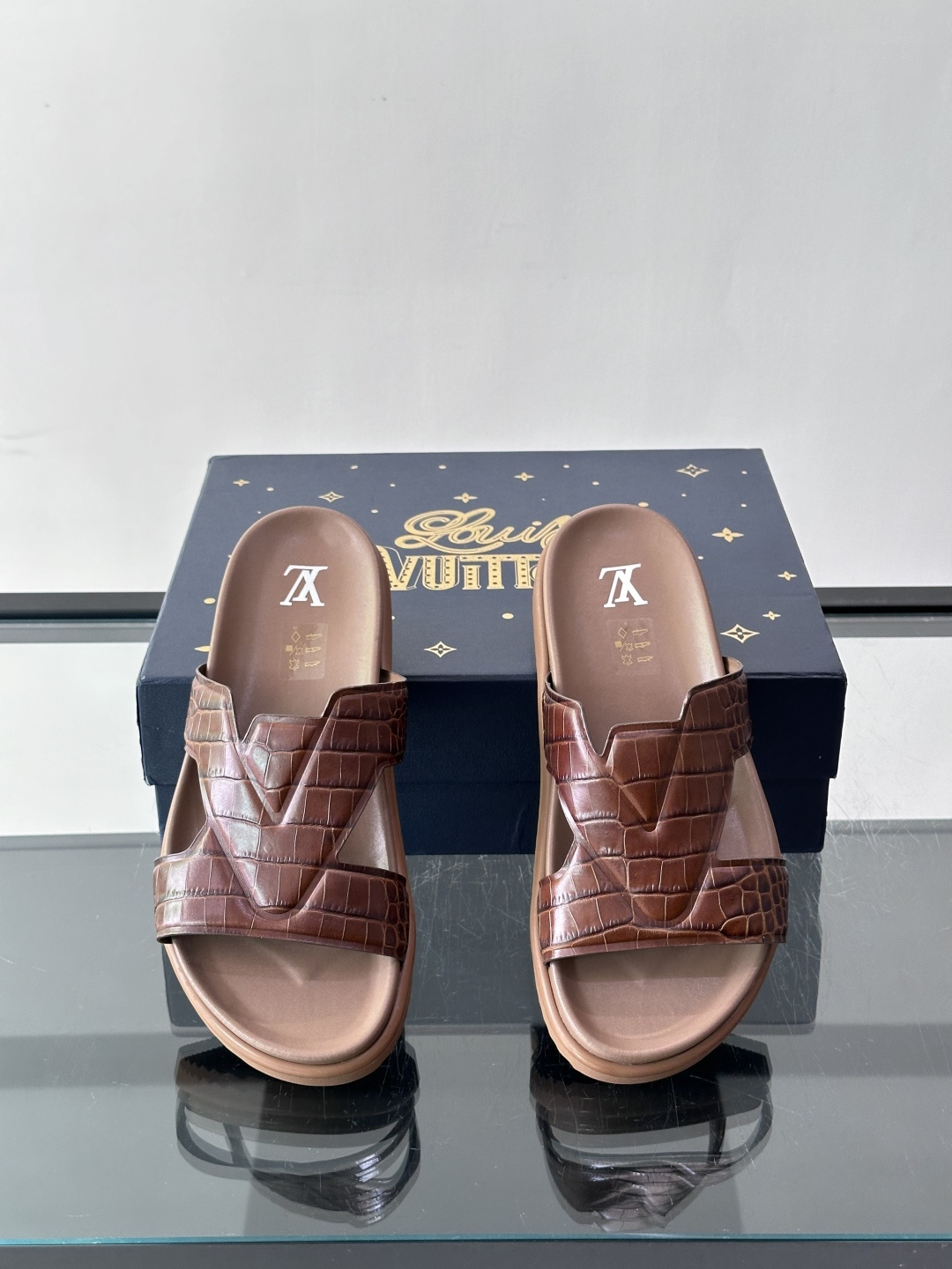 Louis Vuitton 男士皮革拖鞋​​，牛皮交叉带搭配防滑橡胶厚底，鞋垫上有 LV 暗纹 logo。 这款走的是"