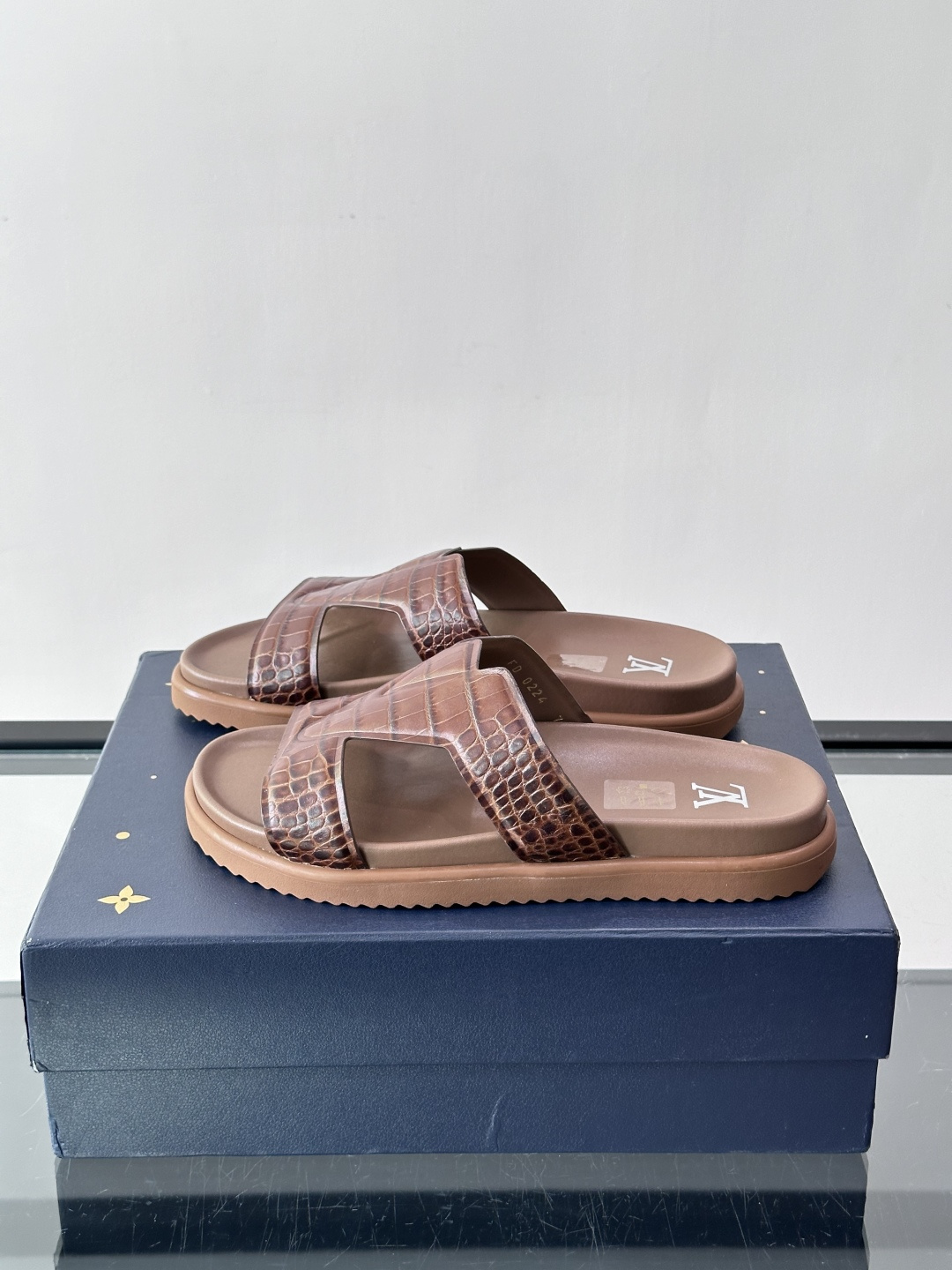 Louis Vuitton 男士皮革拖鞋​​，牛皮交叉带搭配防滑橡胶厚底，鞋垫上有 LV 暗纹 logo。 这款走的是"