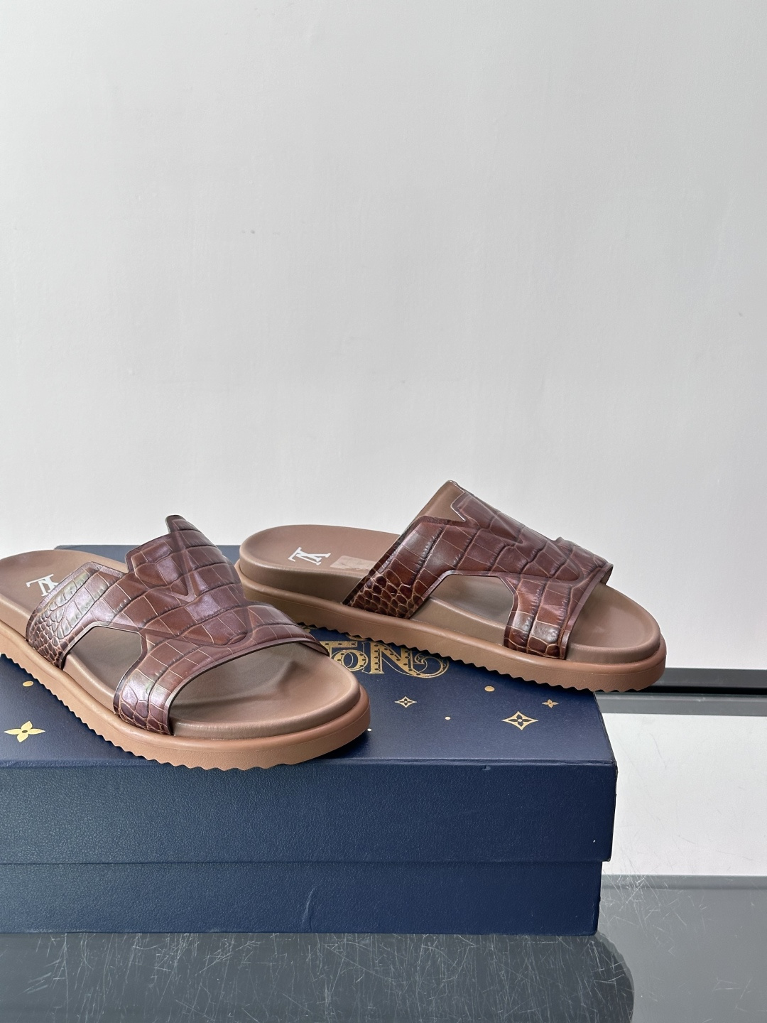 Louis Vuitton 男士皮革拖鞋​​，牛皮交叉带搭配防滑橡胶厚底，鞋垫上有 LV 暗纹 logo。 这款走的是"