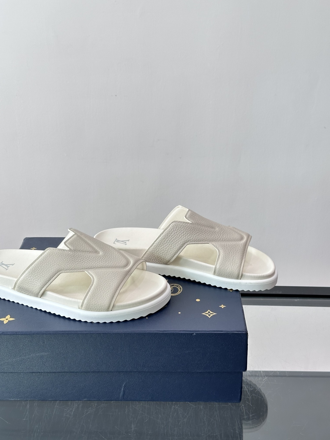 Louis Vuitton 男士皮革拖鞋​​，牛皮交叉带搭配防滑橡胶厚底，鞋垫上有 LV 暗纹 logo。 这款走的是"
