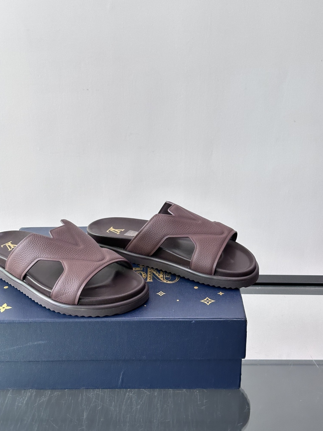 Louis Vuitton 男士皮革拖鞋​​，牛皮交叉带搭配防滑橡胶厚底，鞋垫上有 LV 暗纹 logo。 这款走的是"