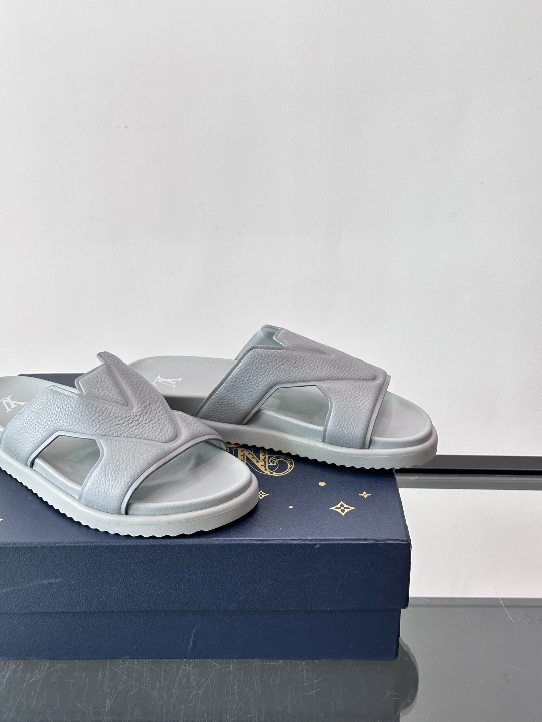 Louis Vuitton 男士皮革拖鞋​​，牛皮交叉带搭配防滑橡胶厚底，鞋垫上有 LV 暗纹 logo。 这款走的是"