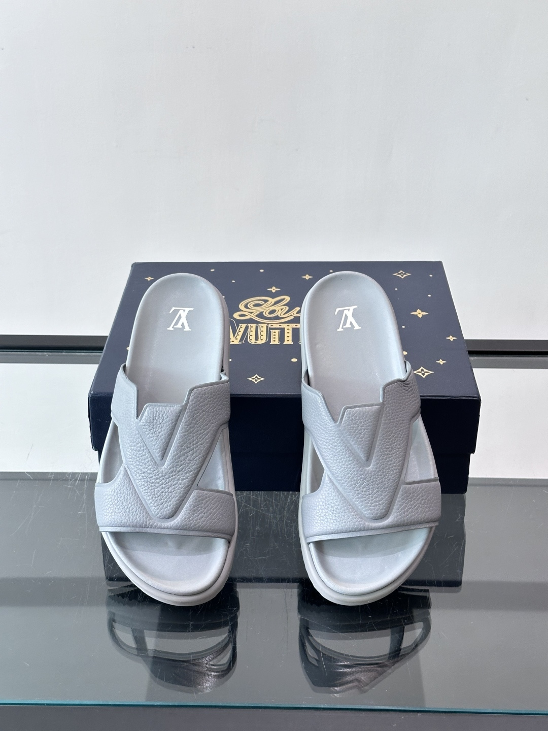 Louis Vuitton 男士皮革拖鞋​​，牛皮交叉带搭配防滑橡胶厚底，鞋垫上有 LV 暗纹 logo。 这款走的是"