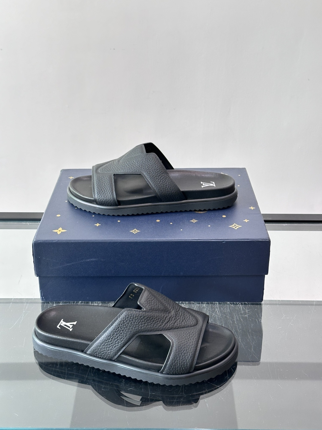 Louis Vuitton 男士皮革拖鞋​​，牛皮交叉带搭配防滑橡胶厚底，鞋垫上有 LV 暗纹 logo。 这款走的是"