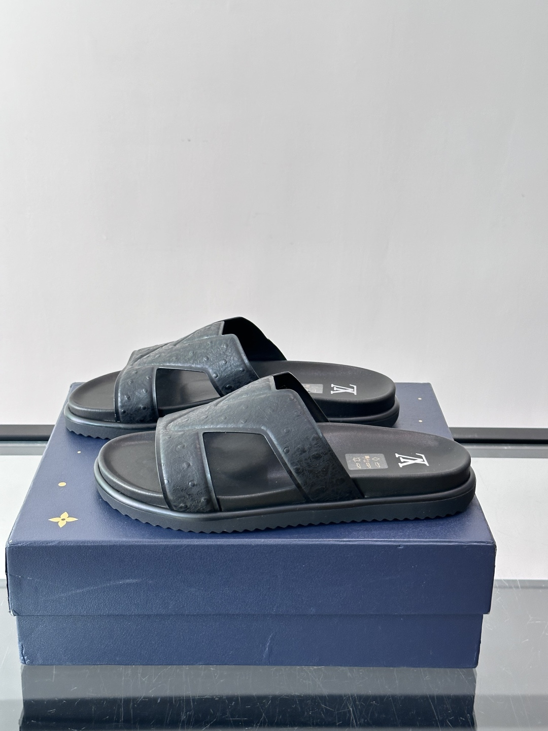 Louis Vuitton 男士皮革拖鞋​​，牛皮交叉带搭配防滑橡胶厚底，鞋垫上有 LV 暗纹 logo。 这款走的是"