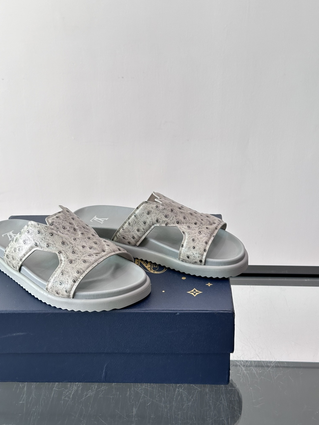 Louis Vuitton 男士皮革拖鞋​​，牛皮交叉带搭配防滑橡胶厚底，鞋垫上有 LV 暗纹 logo。 这款走的是"