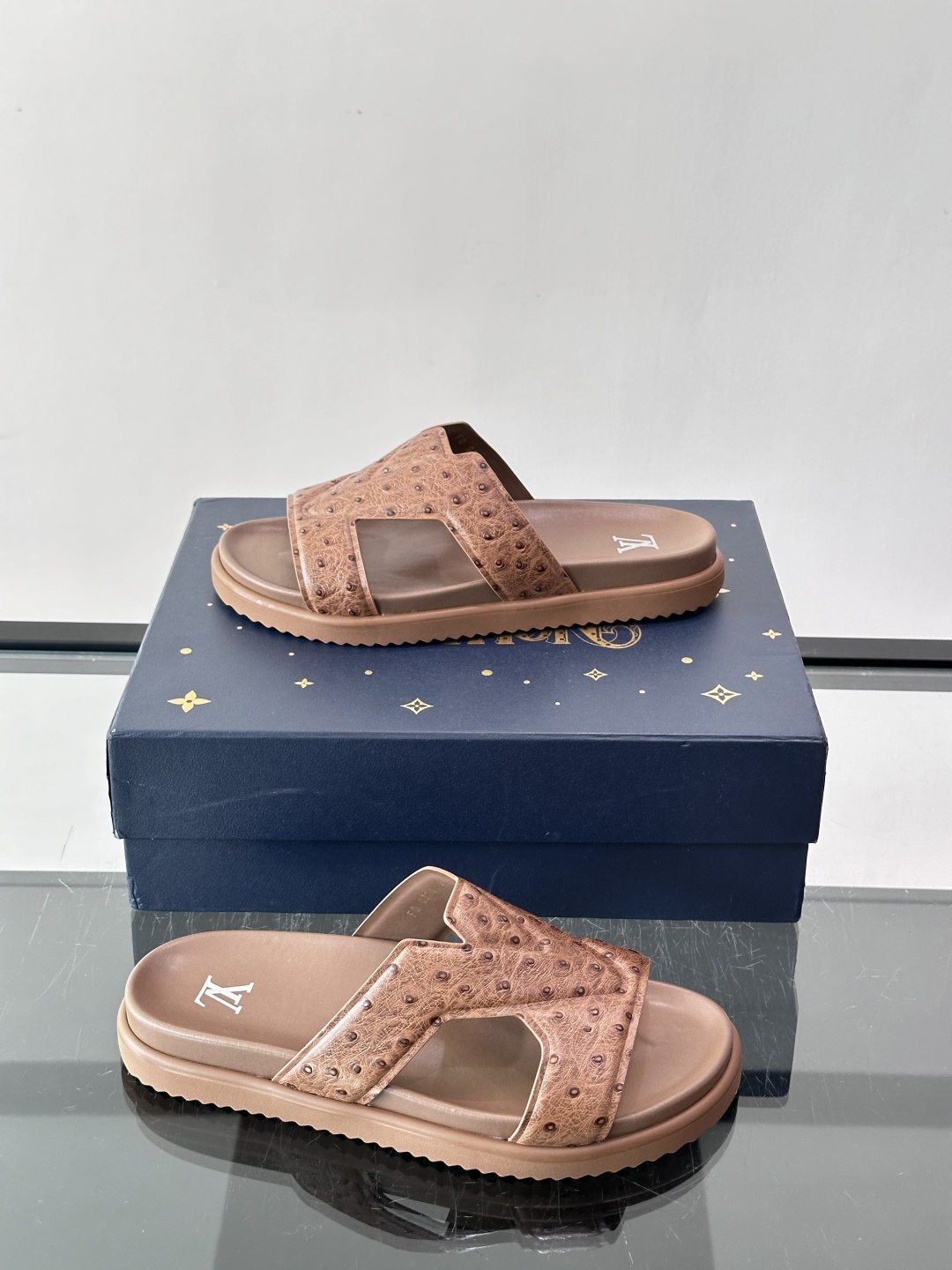 Louis Vuitton 男士皮革拖鞋​​，牛皮交叉带搭配防滑橡胶厚底，鞋垫上有 LV 暗纹 logo。 这款走的是"