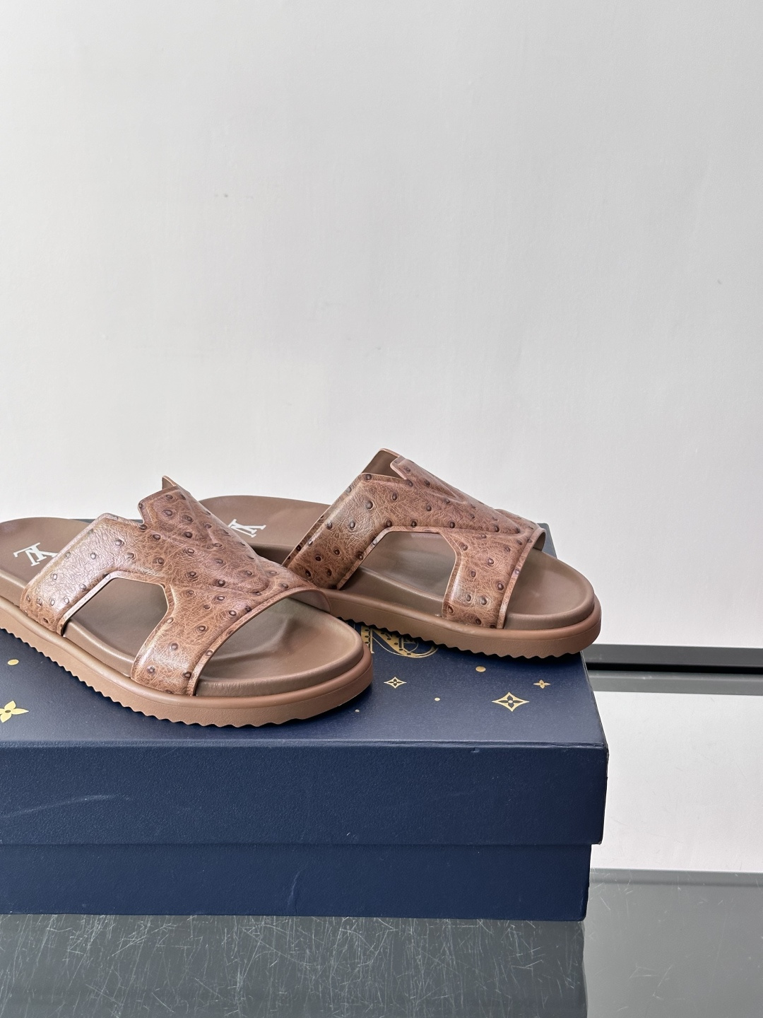 Louis Vuitton 男士皮革拖鞋​​，牛皮交叉带搭配防滑橡胶厚底，鞋垫上有 LV 暗纹 logo。 这款走的是"