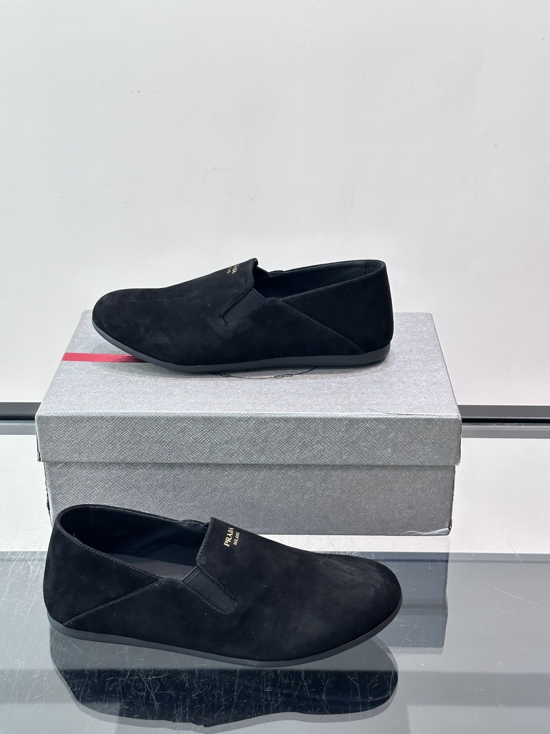 ​​Prada 麂皮一脚蹬乐福鞋​​，翻毛皮鞋面，鞋面顶部有金色"PRADA MILANO"字样烫印，鞋垫上也是 PRA