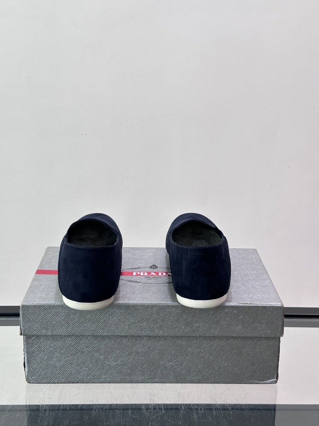 ​​Prada 麂皮一脚蹬乐福鞋​​，翻毛皮鞋面，鞋面顶部有金色"PRADA MILANO"字样烫印，鞋垫上也是 PRA