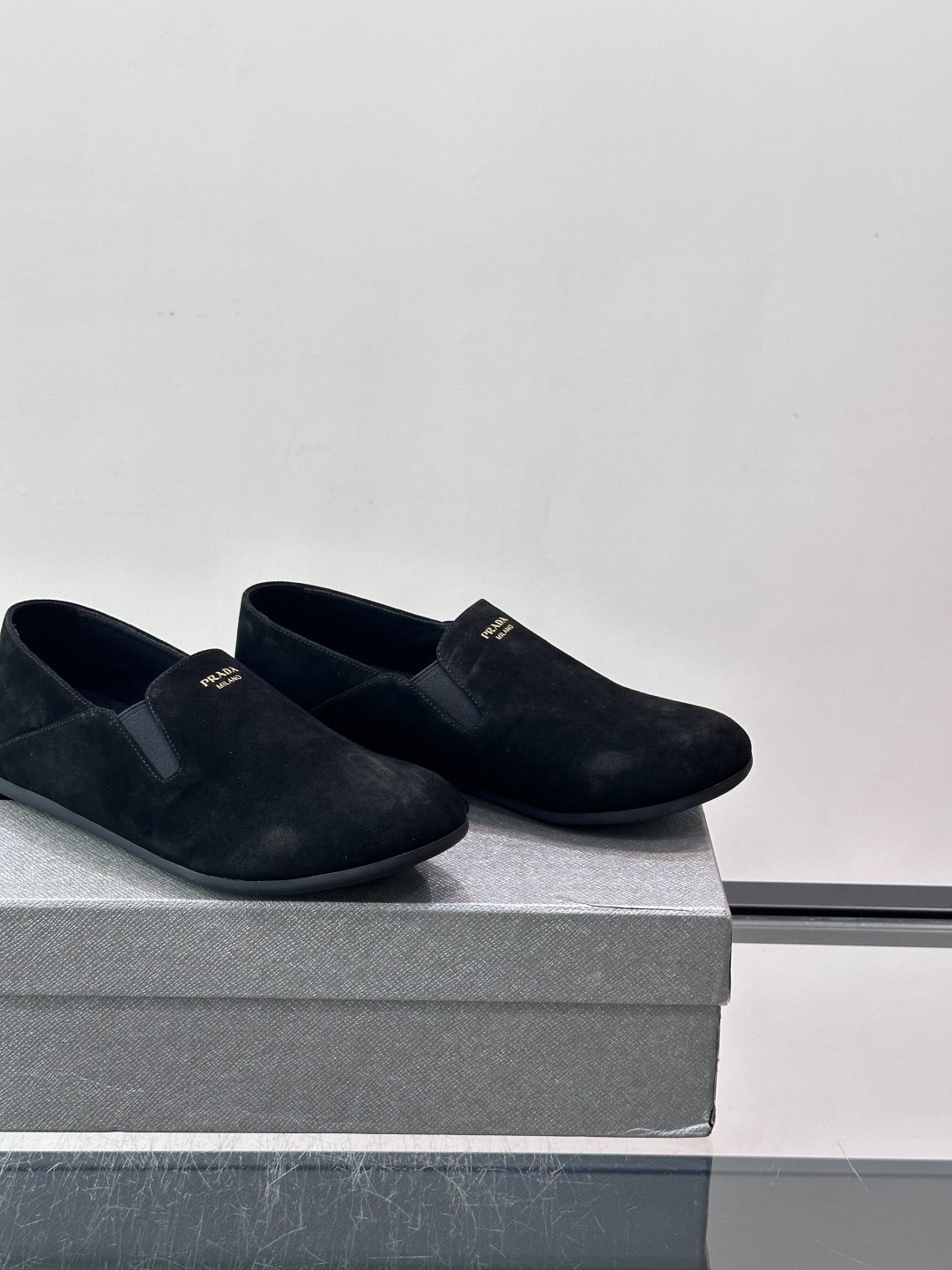 ​​Prada 麂皮一脚蹬乐福鞋​​，翻毛皮鞋面，鞋面顶部有金色"PRADA MILANO"字样烫印，鞋垫上也是 PRA