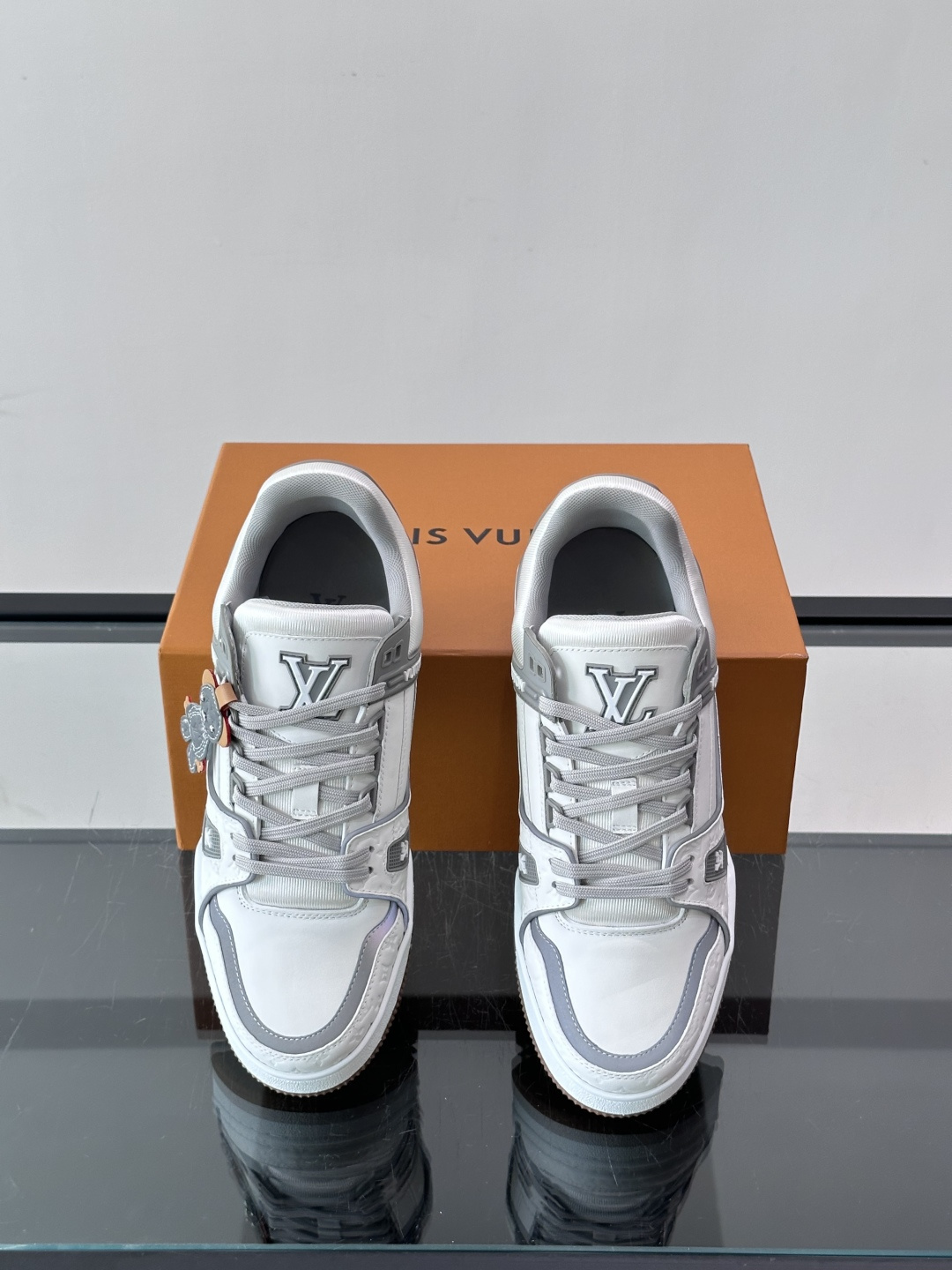 LV TRAINER 运动鞋 本款 LV Trainer 运动鞋巧妙融合素面与 Monogram 压纹牛皮革，Louis