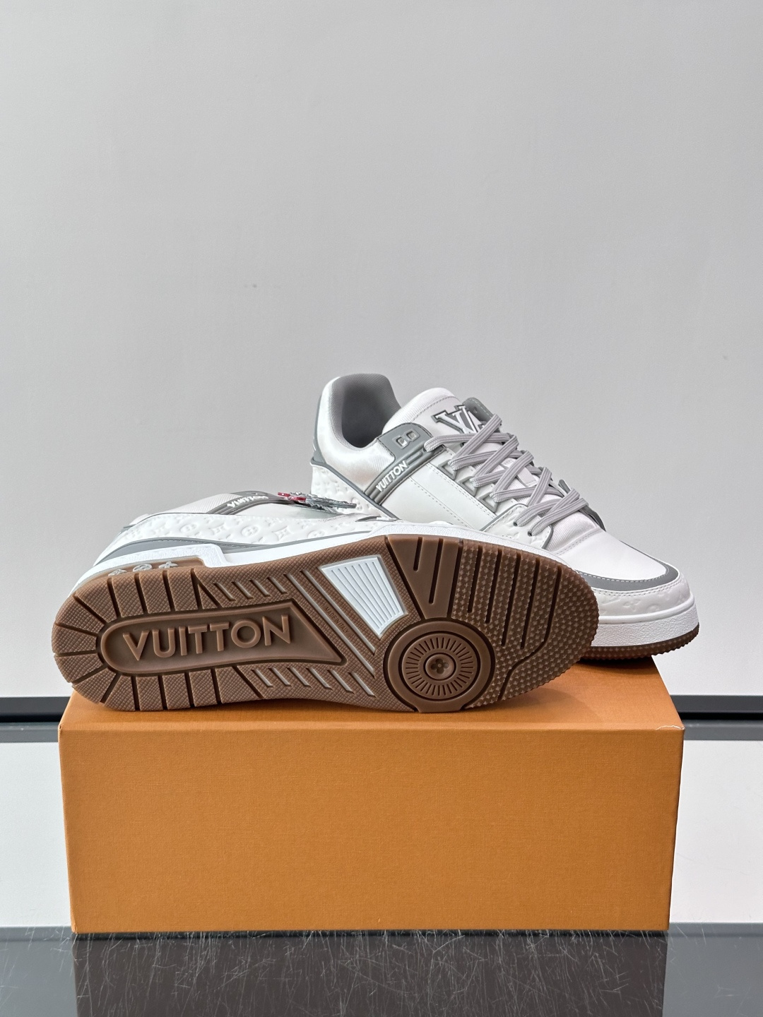 LV TRAINER 运动鞋 本款 LV Trainer 运动鞋巧妙融合素面与 Monogram 压纹牛皮革，Louis