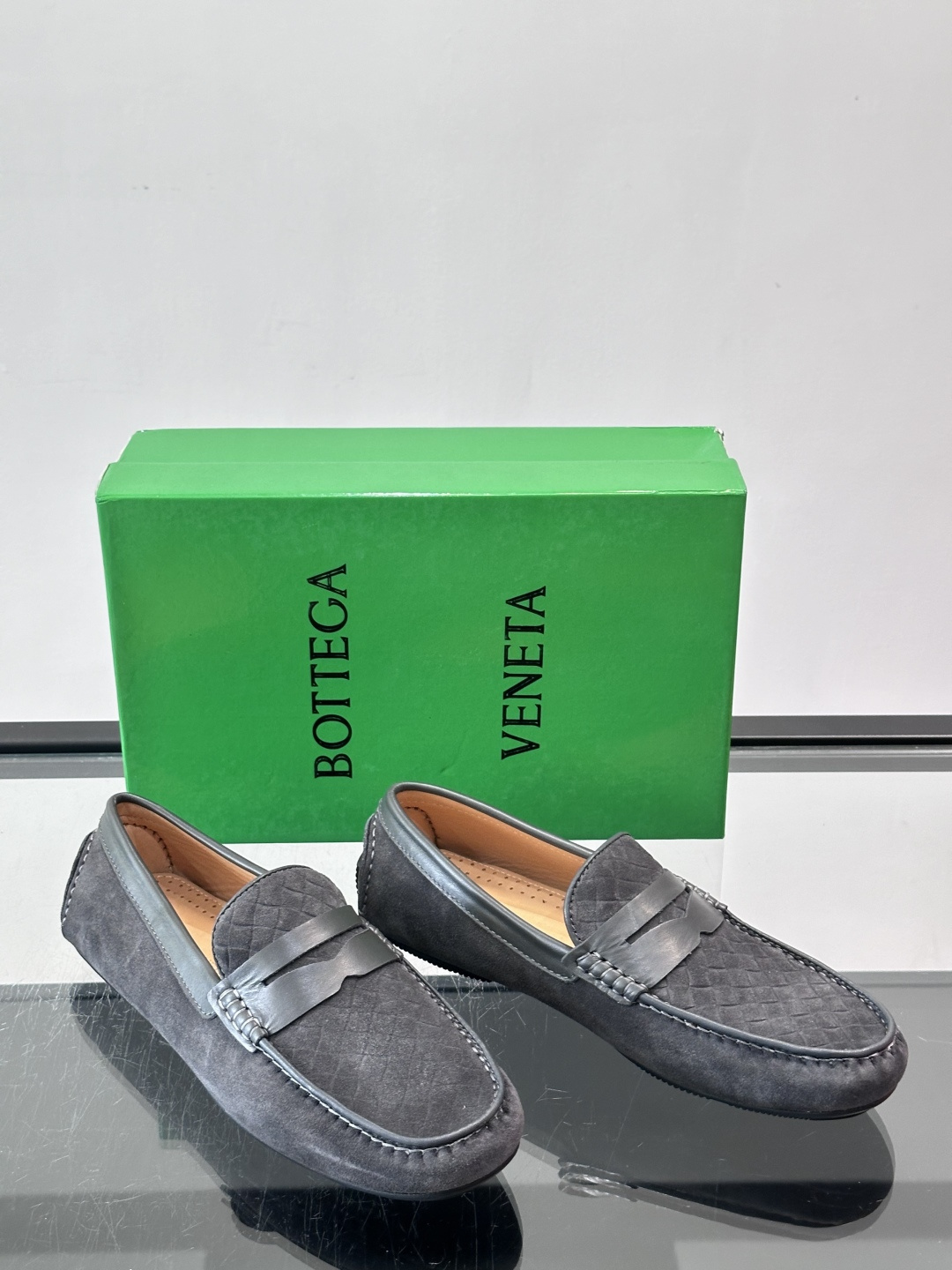 Bottega Veneta  编织豆豆鞋​​，编织皮革鞋面，橡胶豆豆颗粒鞋底，包边缝线细节。背景能看到 BV 的经典绿