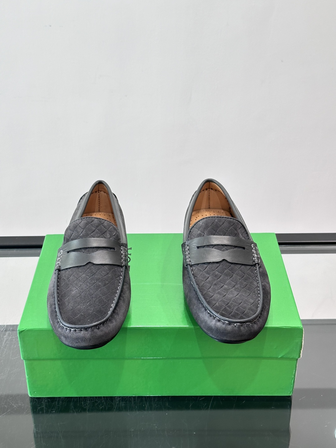 Bottega Veneta  编织豆豆鞋​​，编织皮革鞋面，橡胶豆豆颗粒鞋底，包边缝线细节。背景能看到 BV 的经典绿