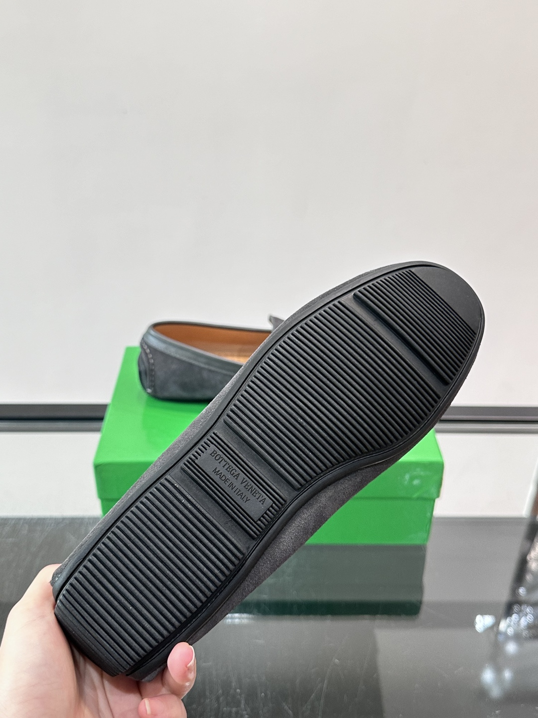 Bottega Veneta  编织豆豆鞋​​，编织皮革鞋面，橡胶豆豆颗粒鞋底，包边缝线细节。背景能看到 BV 的经典绿