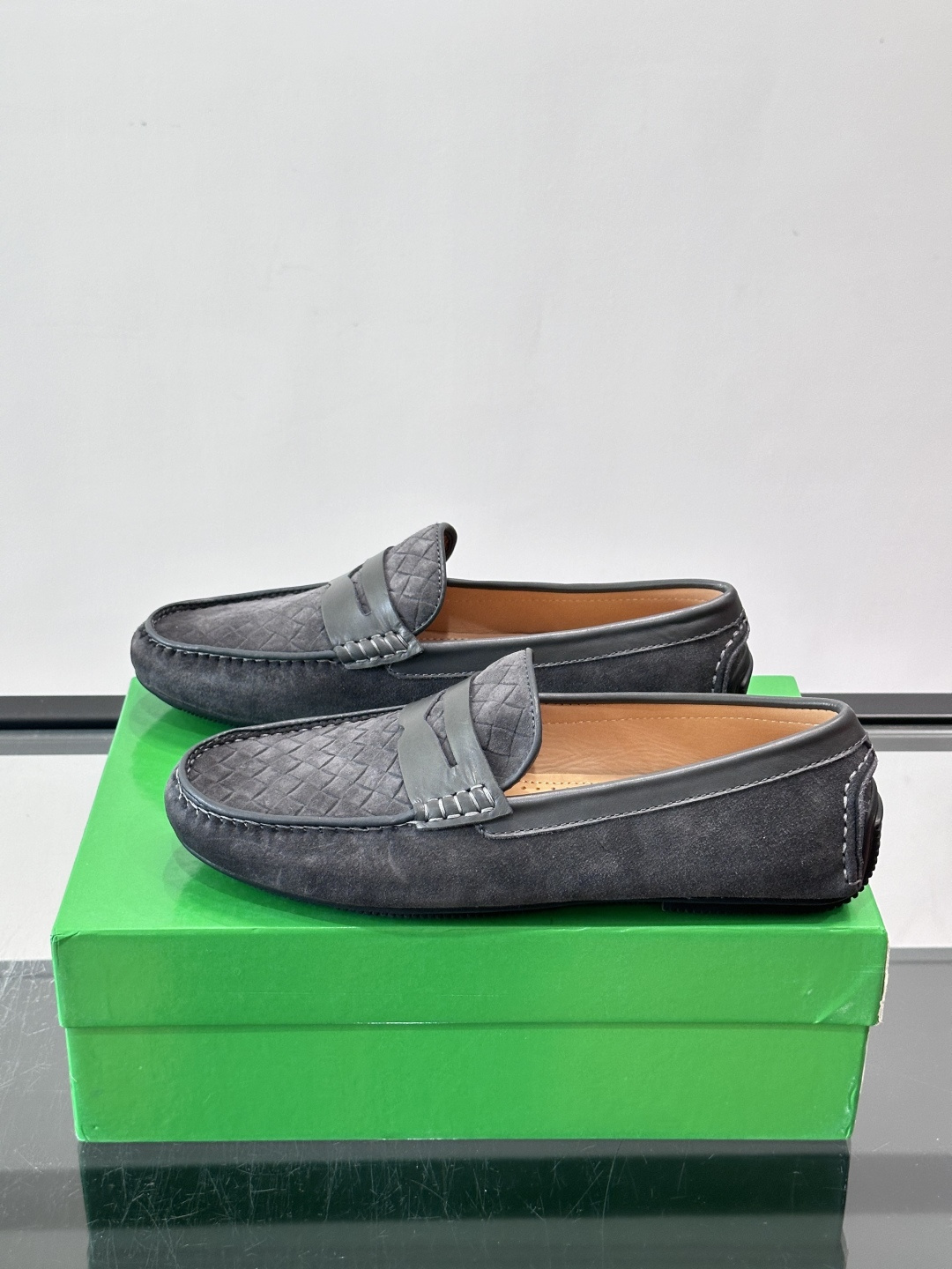 Bottega Veneta  编织豆豆鞋​​，编织皮革鞋面，橡胶豆豆颗粒鞋底，包边缝线细节。背景能看到 BV 的经典绿