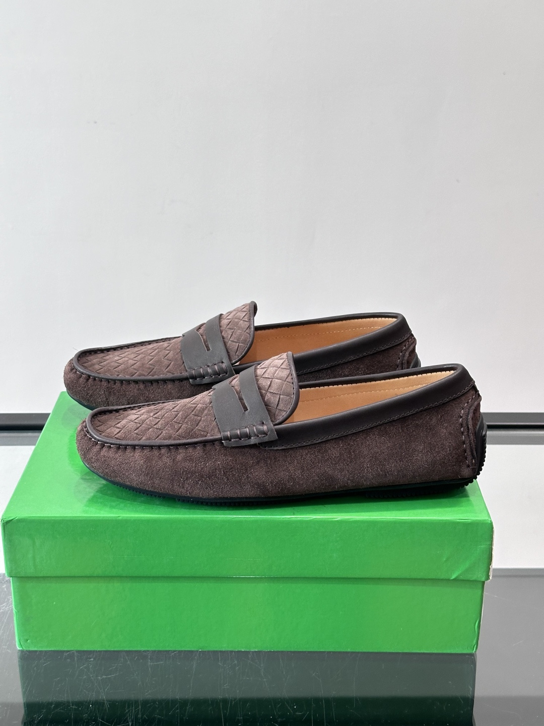 Bottega Veneta  编织豆豆鞋​​，编织皮革鞋面，橡胶豆豆颗粒鞋底，包边缝线细节。背景能看到 BV 的经典绿