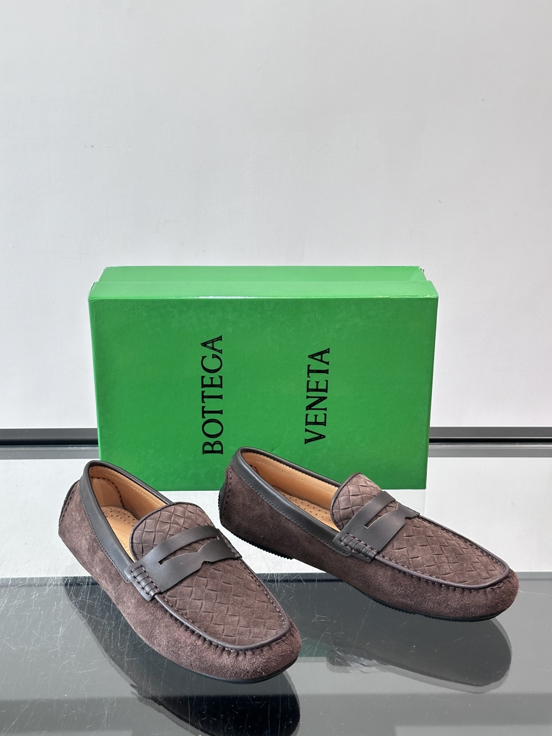 Bottega Veneta  编织豆豆鞋​​，编织皮革鞋面，橡胶豆豆颗粒鞋底，包边缝线细节。背景能看到 BV 的经典绿