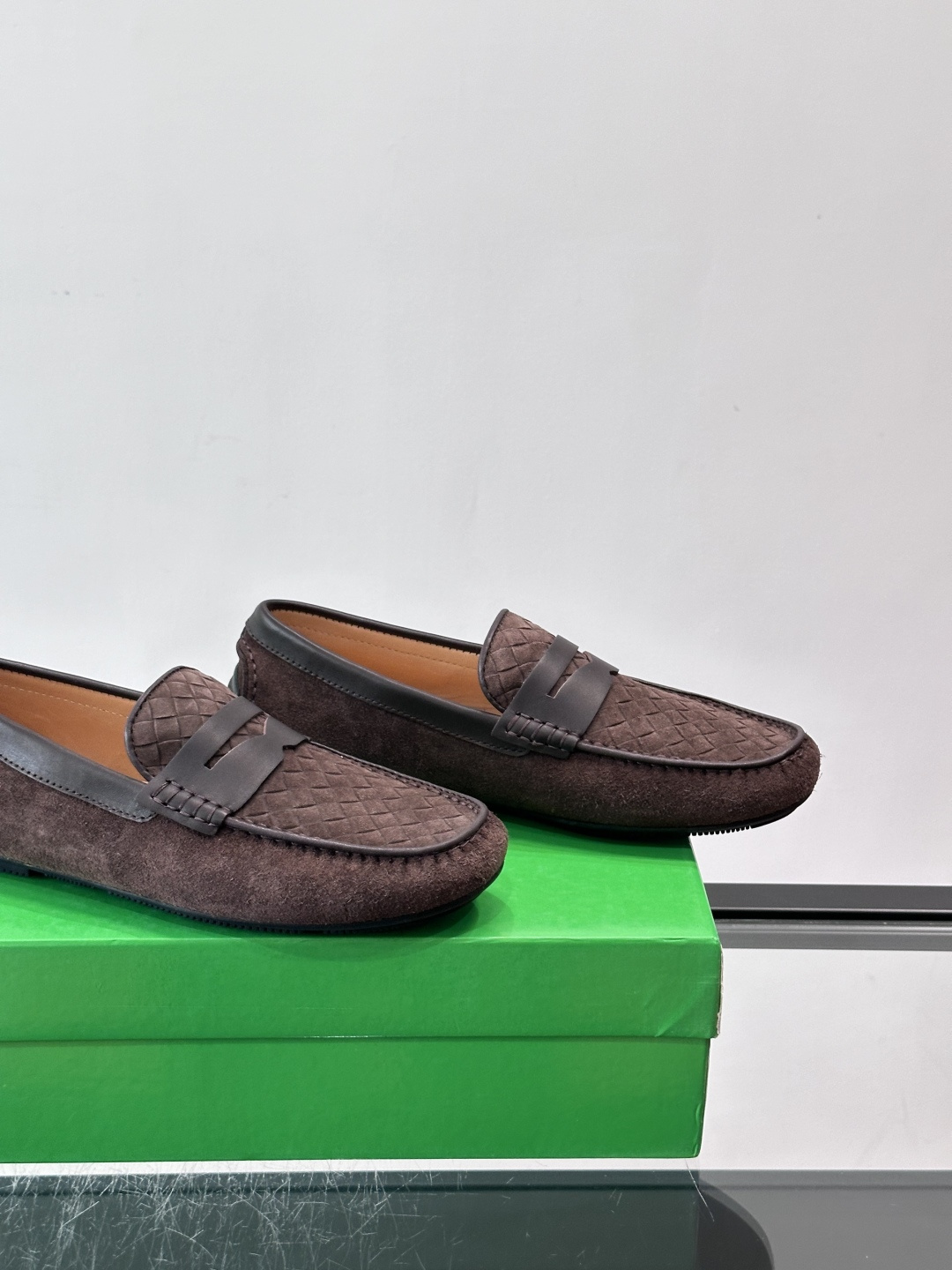 Bottega Veneta  编织豆豆鞋​​，编织皮革鞋面，橡胶豆豆颗粒鞋底，包边缝线细节。背景能看到 BV 的经典绿