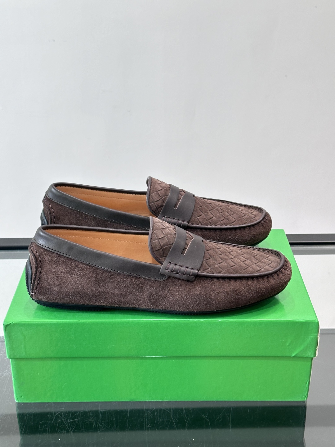 Bottega Veneta  编织豆豆鞋​​，编织皮革鞋面，橡胶豆豆颗粒鞋底，包边缝线细节。背景能看到 BV 的经典绿