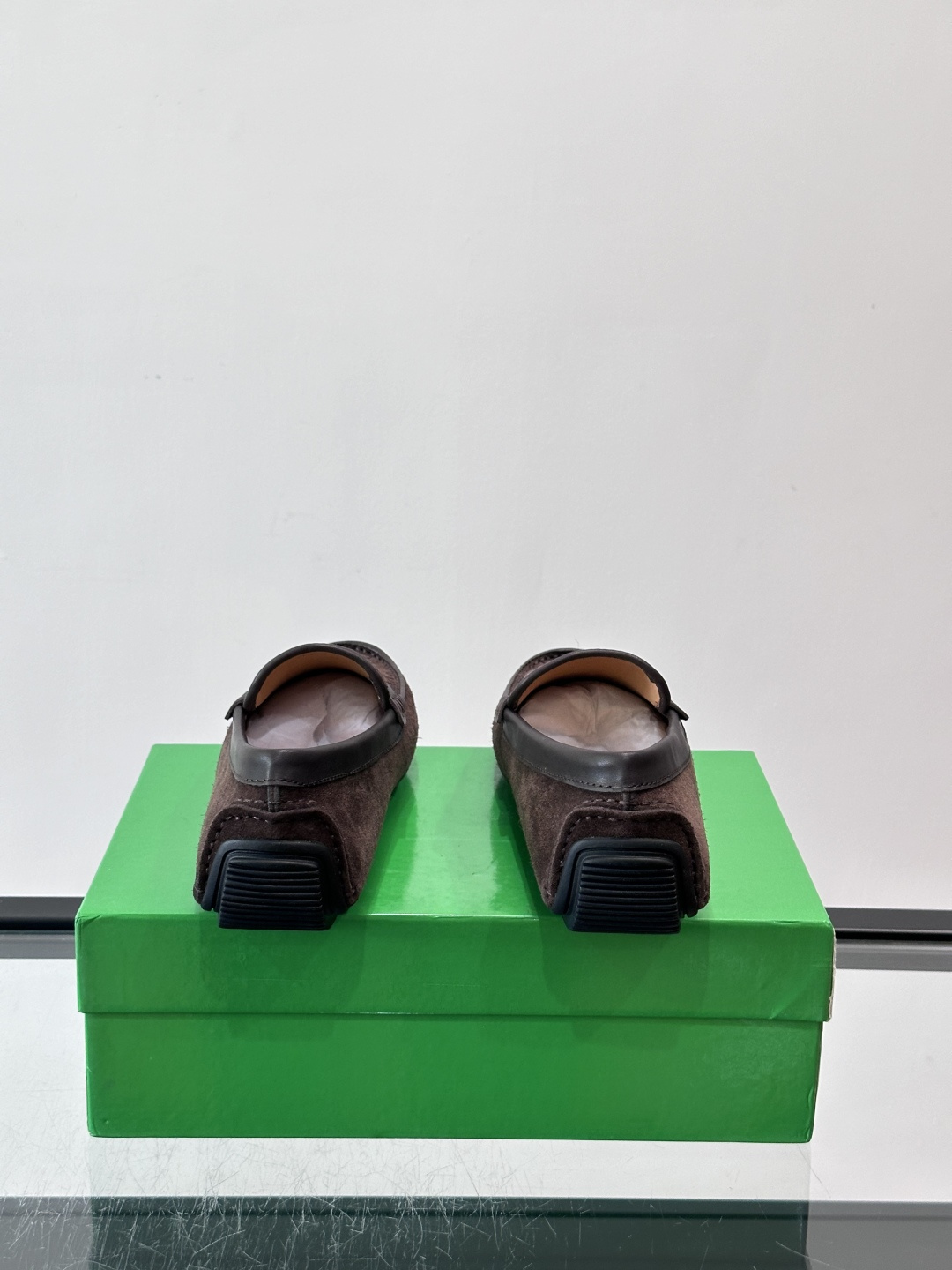 Bottega Veneta  编织豆豆鞋​​，编织皮革鞋面，橡胶豆豆颗粒鞋底，包边缝线细节。背景能看到 BV 的经典绿