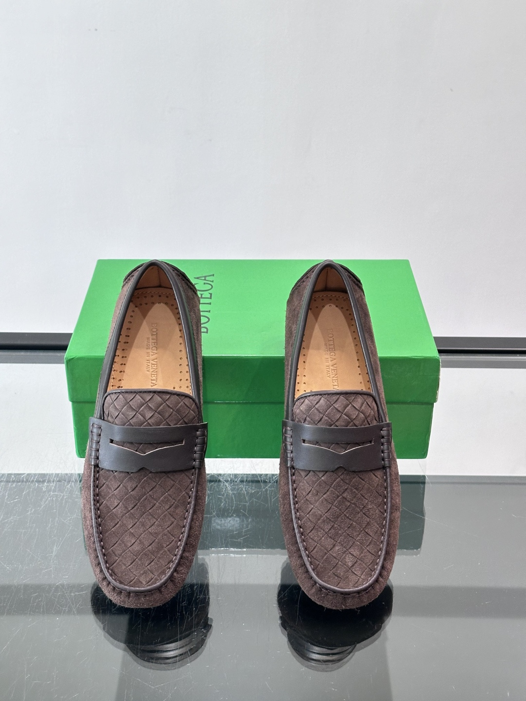 Bottega Veneta  编织豆豆鞋​​，编织皮革鞋面，橡胶豆豆颗粒鞋底，包边缝线细节。背景能看到 BV 的经典绿