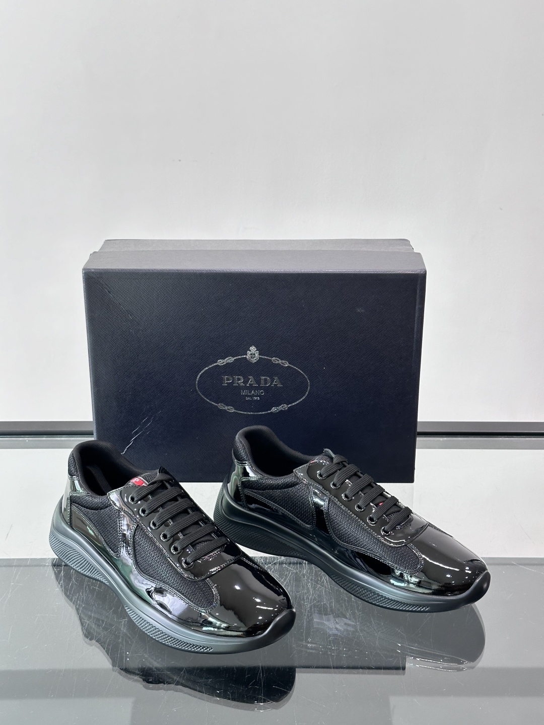 Prada 美洲杯运动鞋​​ ✨Prada美洲杯系列运动鞋，漆皮+网面拼接，光泽感与透气性兼具。低帮设计，白色橡胶鞋底，