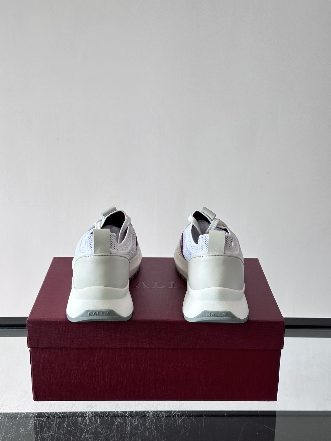 ​​BALLY（巴利）男士针织袜套鞋​​，飞织网面鞋身，一脚蹬的袜套式设计，厚底，鞋跟处有酒红色提环细节。这款走的是”轻
