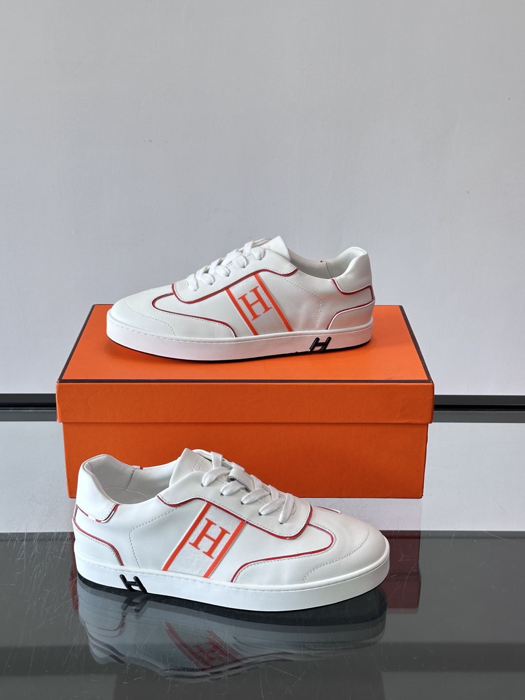 ​​Hermès 男士休闲运动鞋​​，皮革鞋面，鞋侧有橙色 H logo 织带装饰，白色橡胶鞋底。 In-the-Loo