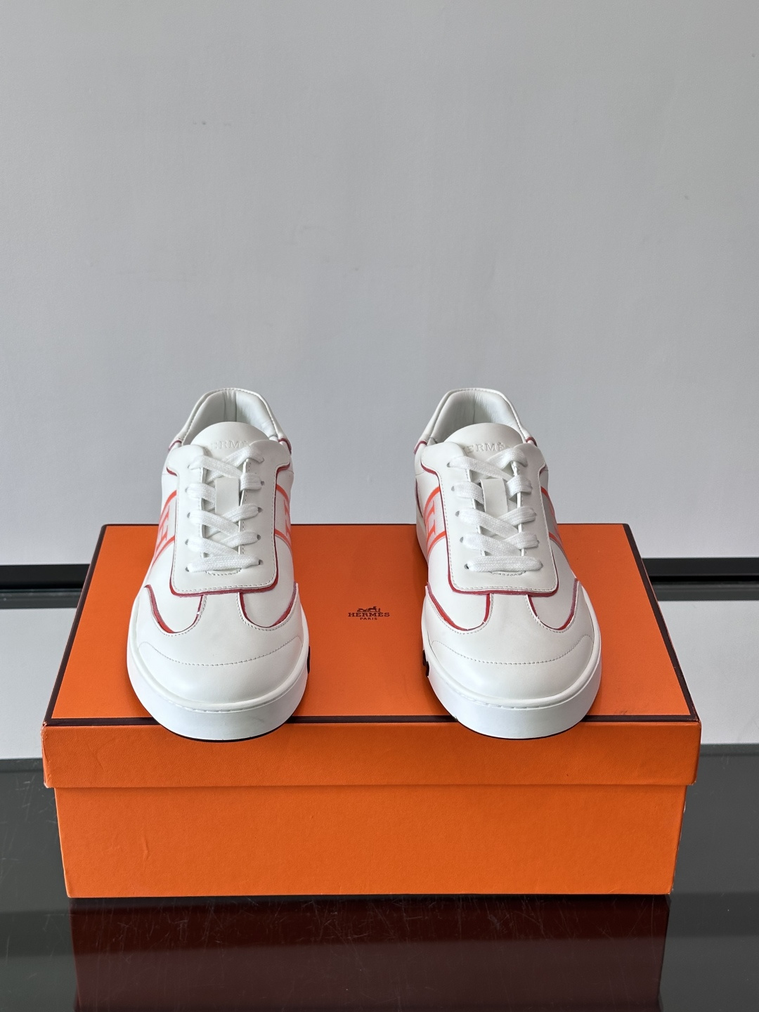 ​​Hermès 男士休闲运动鞋​​，皮革鞋面，鞋侧有橙色 H logo 织带装饰，白色橡胶鞋底。 In-the-Loo